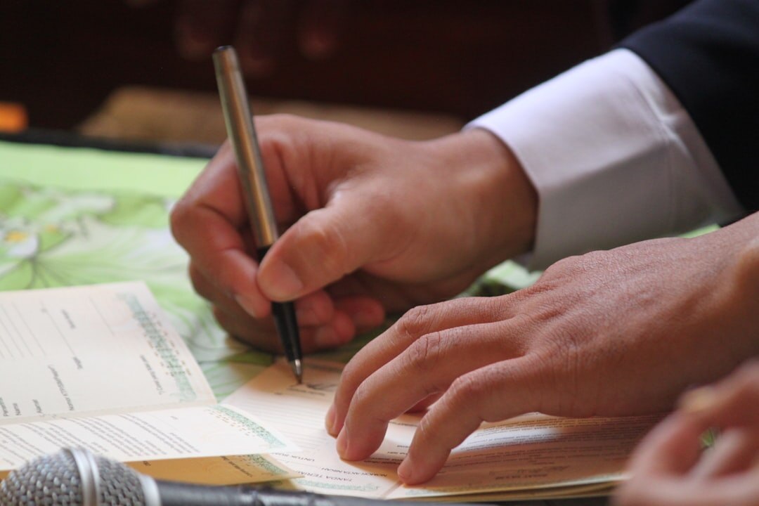 Close-up of a hand signing an official document with a pen